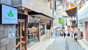 A narrow street with shops and a hotel named HOTEL LITAN. - Hotel Litan Machu Picchu (Aguas Calientes)