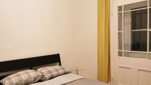 Ein Bett mit Kopfteil, zwei Kissen und einer gestreiften Decke.