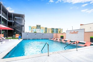 A swimming pool with a no diving sign, lounge chairs, and a building with a 'Homewood Suites' sign in the background. - Creekside Modern - Community Pool | Ping Pong (New Braunfels)