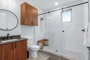 The full ensuite bath features a single vanity & large glass shower - Creekside Modern - Community Pool | Ping Pong (New Braunfels)