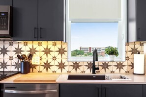 The sleek, open kitchen offers ample space & every home comfort