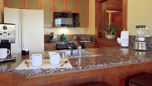 A kitchen with granite countertops, stainless steel appliances, wooden cabinets, and a central island with a sink. - Hyatt High Sierra Lodge - charming 2-bedroom condo in wonderful Incline Village (Incline Village)