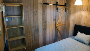 A wooden room with a bed, a ladder, and a shelf unit. - Camping 2000 - Sahara tent XXL (Osecná)