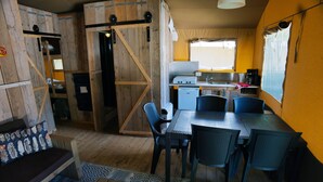 A compact kitchen with a sink, stove, and refrigerator. There is a dining area with a table and chairs. - Camping 2000 - Sahara tent XXL (Osecná)