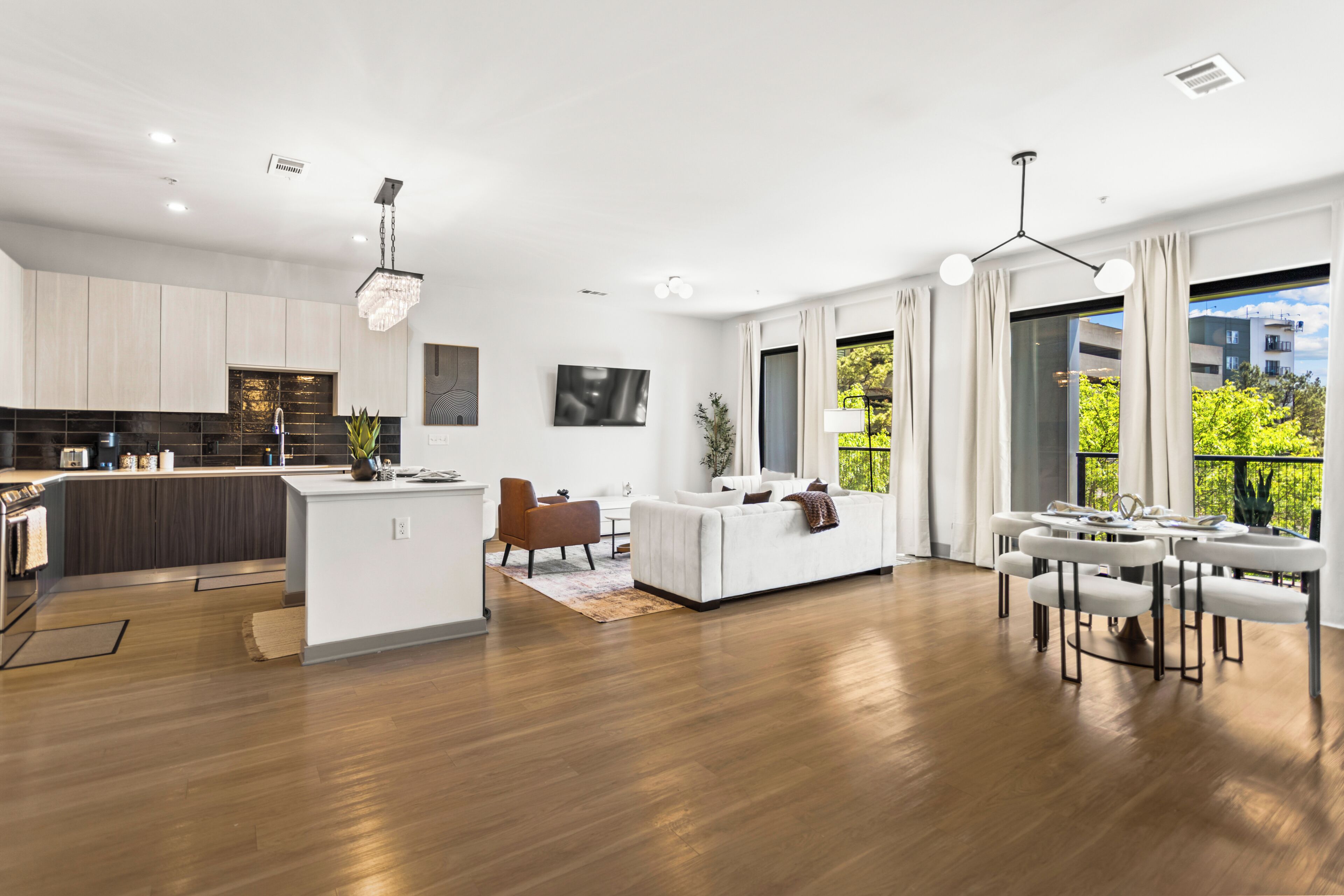 A modern apartment with a kitchen, living area, and balcony.