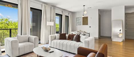 A modern living room with a sofa set, a coffee table, and a dining area with a table and chairs.