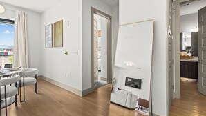 A modern living room with a sofa, a dining table with chairs, and a kitchen area visible through an open door. - Lux Mocha Downtown Self Check-in Balcony (Atlanta)