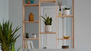 A modern living room with a black chair, wooden shelves, and a small table with a record player. - ROSEMONT: Nice apartment 2 steps from Molson Park! (Montréal)