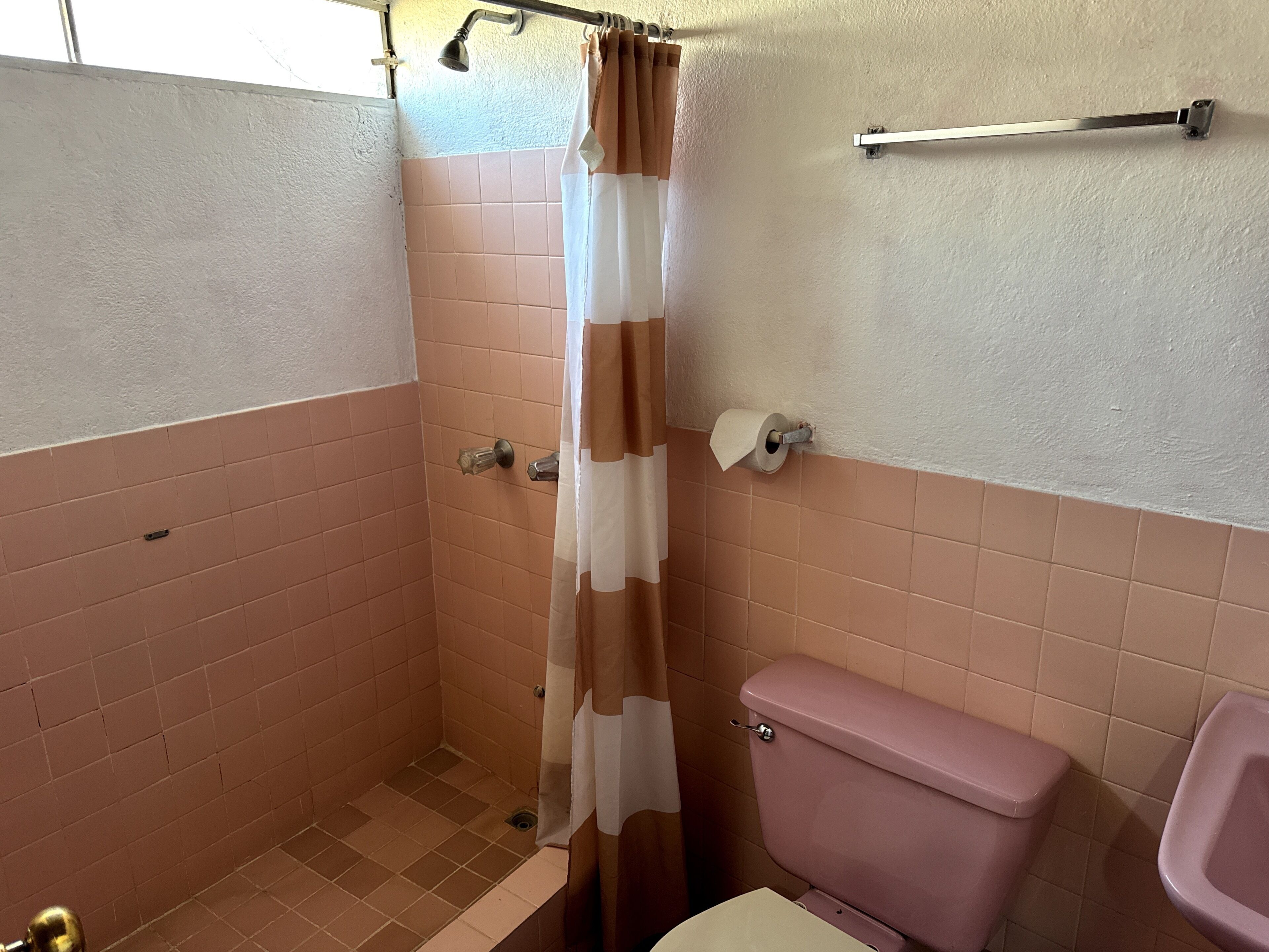 A bathroom with a shower, toilet, and sink.