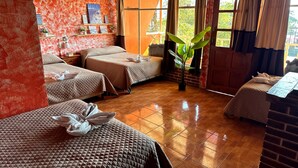Una habitación con dos camas, una planta en maceta y una ventana con cortinas.