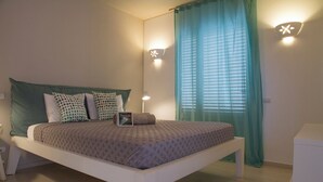 A neatly arranged bedroom with a bed, bedside lamps, and a bedside table.