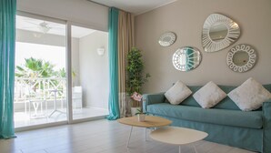 A modern living room with a teal sofa, a coffee table, and decorative mirrors on the wall.