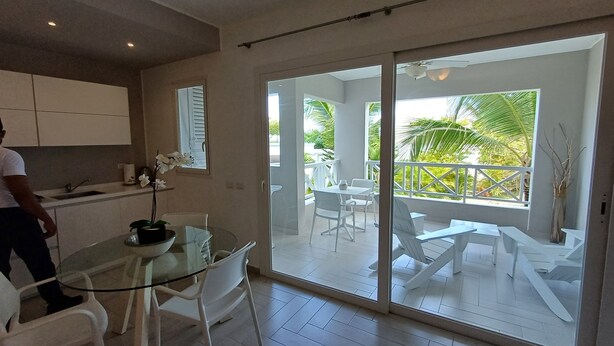 A modern kitchen with white cabinets and a glass dining table. - Tracadero Marina 49 Apt, 1 Hab. (Dominicus)