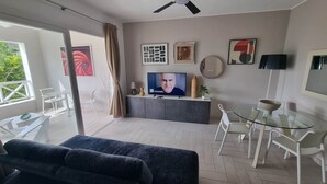 A modern living room with a TV, seating, and a balcony. - Tracadero Marina 49 Apt, 1 Hab. (Dominicus)