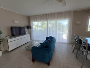 A living room with a sofa, TV, and dining area.