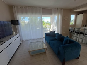 A living room with a sofa, TV, and a small table.