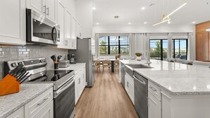 A modern kitchen with white cabinetry, stainless steel appliances, and a large island. - HOGWARTS HEAVEN! Epic Private Theater! Mickey, Mario & Princess! (Orlando)