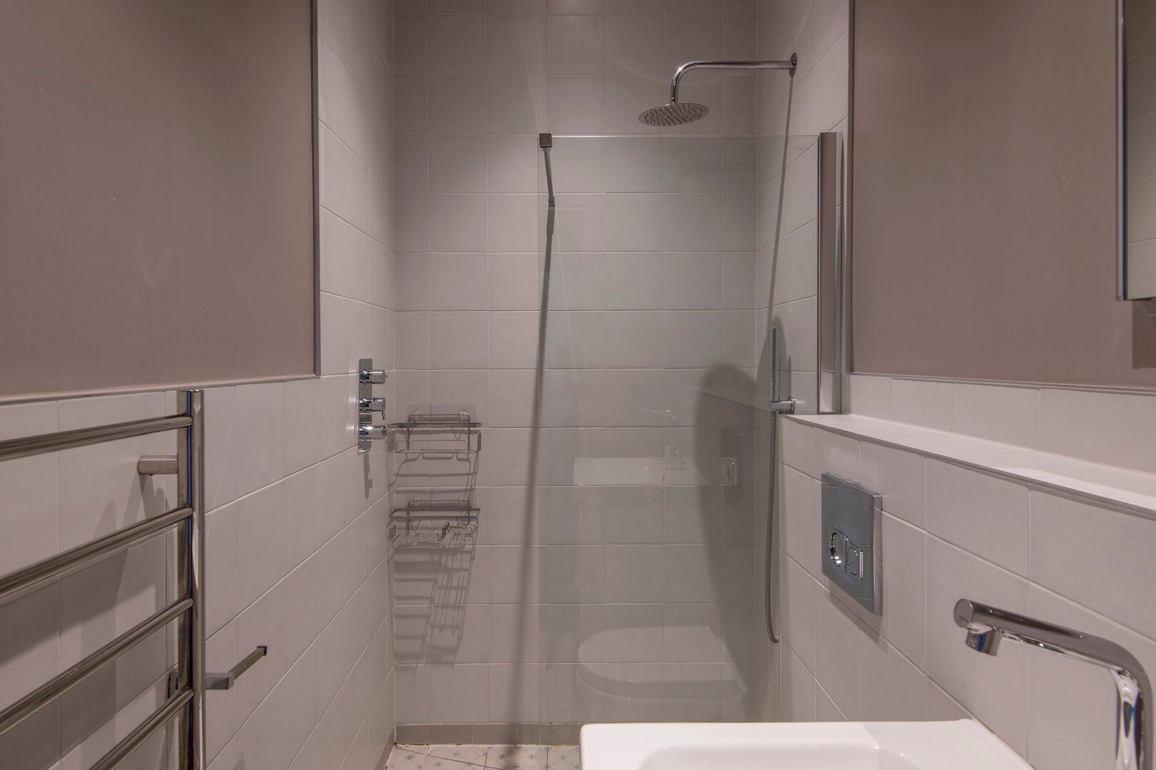Une salle de bain moderne équipée d’une douche, de toilettes et d’un lavabo.