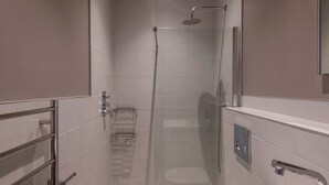 Une salle de bain moderne équipée d’une douche, de toilettes et d’un lavabo.