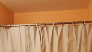 A bathroom with a bathtub, a toilet, and a shower curtain.