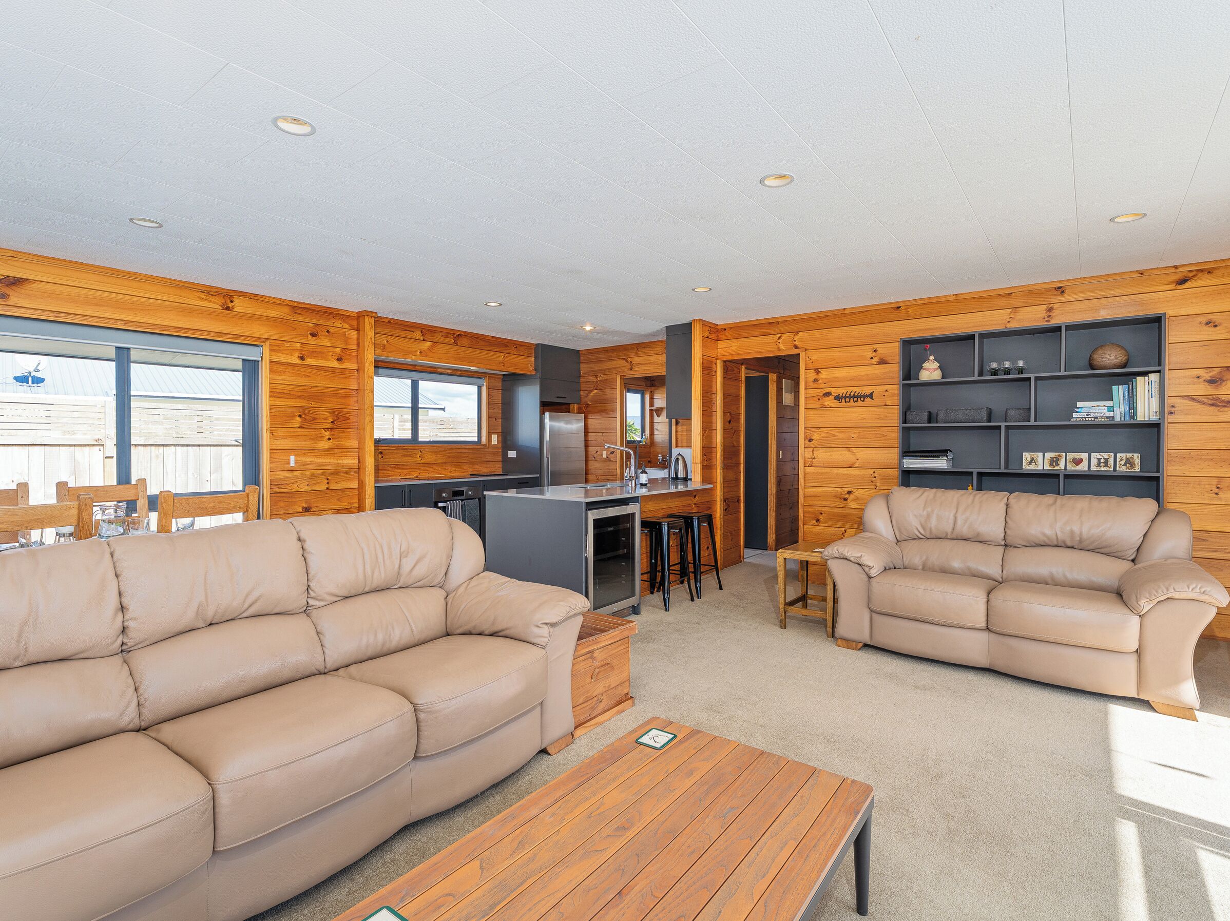 A cozy cabin interior with a living area, kitchen, and dining space.