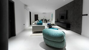 Una sala de estar moderna con sofá, mesa de centro y televisor.