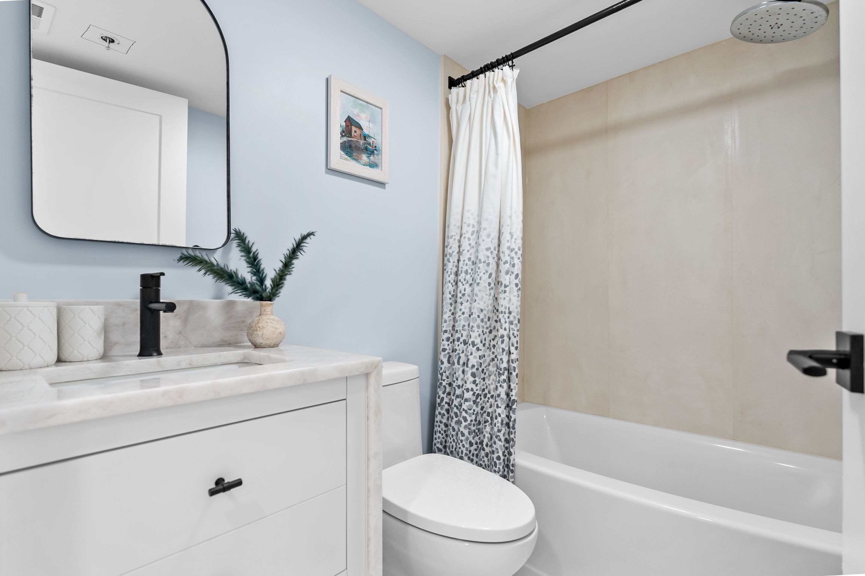 A modern bathroom with a white sink, a toilet, and a bathtub.