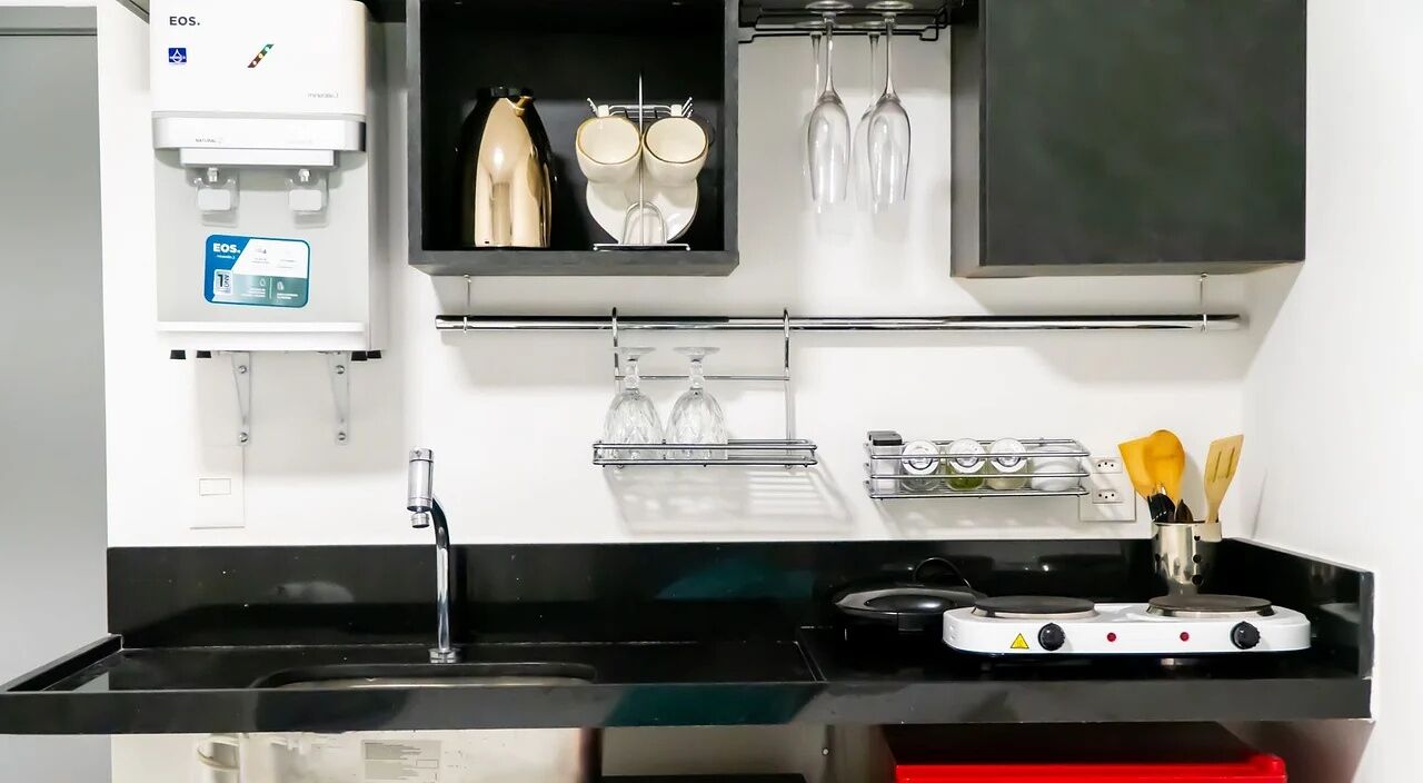Een moderne keuken met een ingebouwde waterdispenser, een fornuis en een spoelbak.