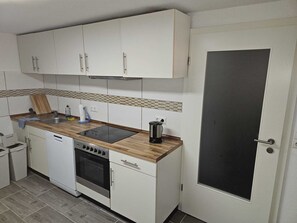 Een koelkast, een oven, een kookplaat, een koffiezetapparaat/waterkoker
