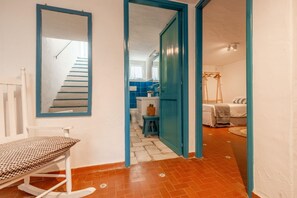 A room with a bed, a chair, a mirror, and a staircase leading to a bathroom. - CASA BIANCA - Charme and relax between Villasimius and Notteri (Notteri)
