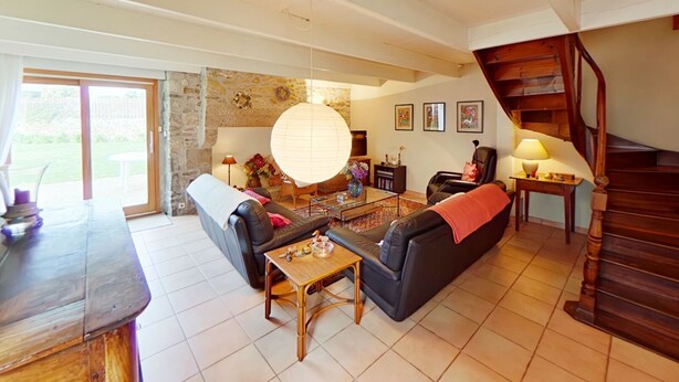 A spacious living room with a large sofa, a coffee table, and a staircase. - Family home - all comforts, in the heart of Roscoff (Roscoff)