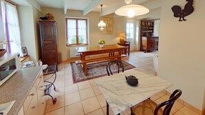 A spacious kitchen with a wooden table, a marble countertop, and a teapot on a small table. - Family home - all comforts, in the heart of Roscoff (Roscoff)