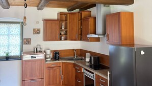 Eine Küche mit Holzausstattung, einem schwarzen Kühlschrank und einem Fenster mit Blick.