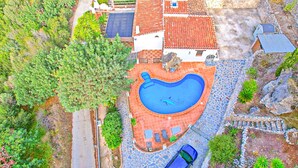 Ein Wohnhaus mit Swimmingpool, einem Auto und einem Garten.