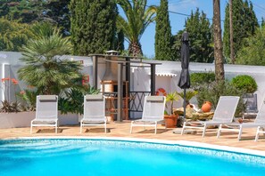 A poolside area with white lounge chairs, a small barbecue grill, and potted plants. - Vale Verde in Lagos With 6 Bedrooms and 4 Bathrooms (Lagos)