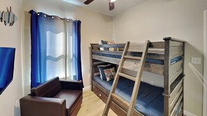 A compact room with a bunk bed, a sofa, and a ladder. - Beach Ballin' by Ryson Vacation Rentals (Galveston)