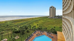 A hotel with a pool, beach view, and palm trees. - Seventh Heaven by Ryson Vacation Rentals (Galveston)