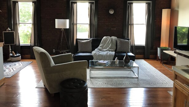 A modern living room with a sofa, armchair, coffee table, and a television. - Cozy studio with AC and WiFi in Historic Geneva, NY.  (Geneva)