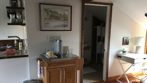 A kitchen with a coffee maker, a trash can, and a cabinet. - Cozy studio with AC and WiFi in Historic Geneva, NY.  (Geneva)