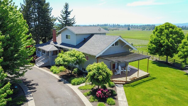 A two-story house with a covered porch and a view of a green field. - Wine Country Farmhouse with Gourmet Kitchen. Perfect for Large Groups. (Dayton)
