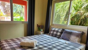 A neatly made bed with a checkered bedspread, a pillow, and a folded towel. - Charming 2-bedroom resort apartement with AC, WiFi in beautiful Willemstad (Willemstad)