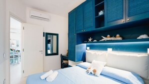 Una habitación de hotel con cama, armario y baño a la vista.
