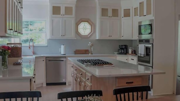A modern kitchen with white cabinetry, a central island, and a dining area with wooden tables and chairs. - 4BR Sleep 12 | Family, Corp Stays | Palo Duro Cyn (Amarillo)