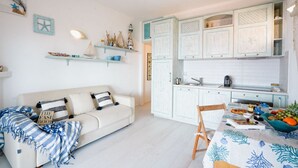 Una sala de estar acogedora con un sofá y una mesa de comedor lista para una comida.
