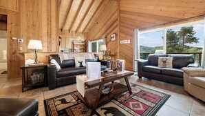 A cozy wooden interior with two leather sofas, a coffee table, and a rug. - Wolf View Lodge (Big Bear City)