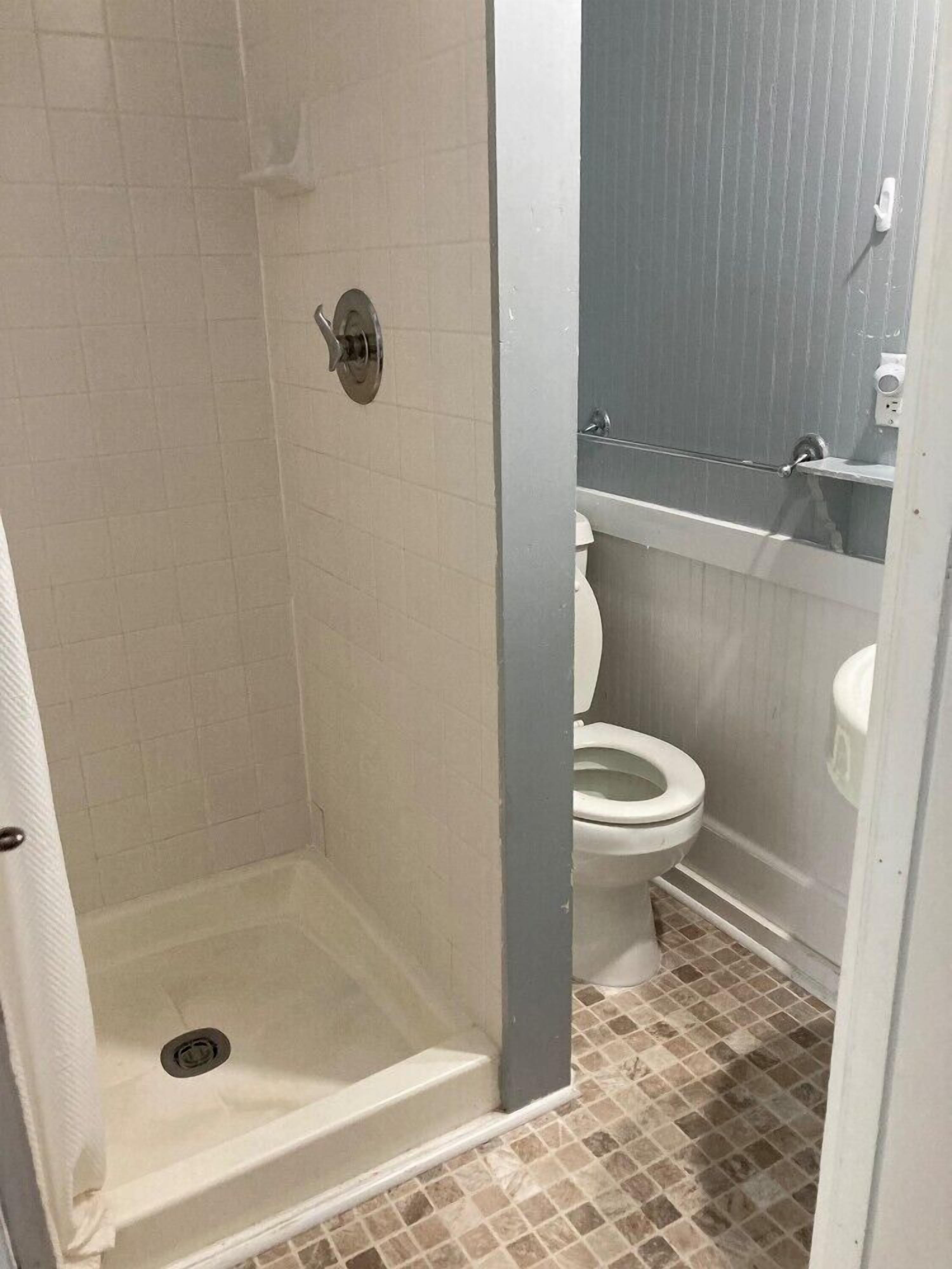 A bathroom with a shower, toilet, and sink.