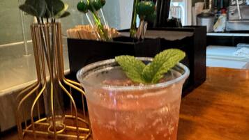 A drink with a mint garnish on a wooden table.