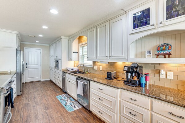 A kitchen with white cabinets, granite countertops, stainless steel appliances, and a coffee maker. - Waterfront Retreat w/ Dock on Cedar Creek Lake! (Kemp)
