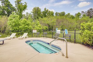 A swimming pool with a metal ladder, surrounded by a fence and several lounge chairs. - 'Mountain Escape' w/ Pool Access in Pigeon Forge! (Pigeon Forge)