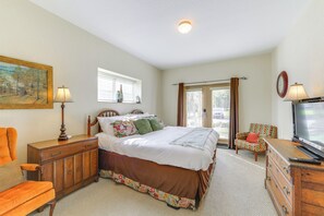 A bedroom with a bed, dresser, TV, and a chair. - 'Mountain Escape' w/ Pool Access in Pigeon Forge! (Pigeon Forge)